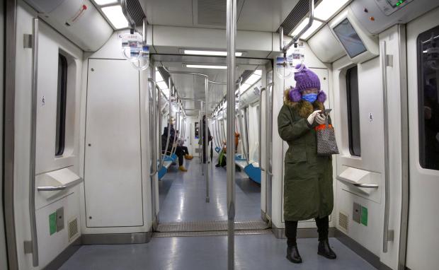  Woman wearing safety googles, mask, and gloves in Beijing train