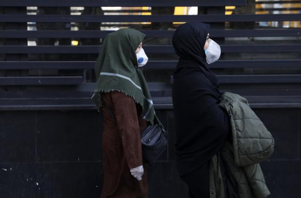  People with masks walking in downtown Tehran