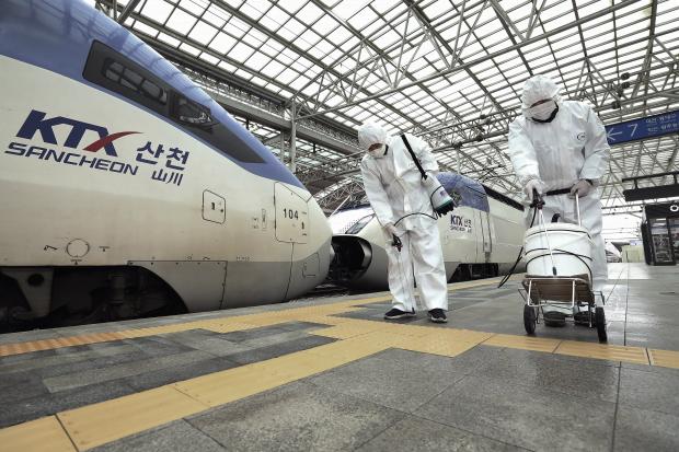 Workers spraying disinfectant at Seoul Railway Station