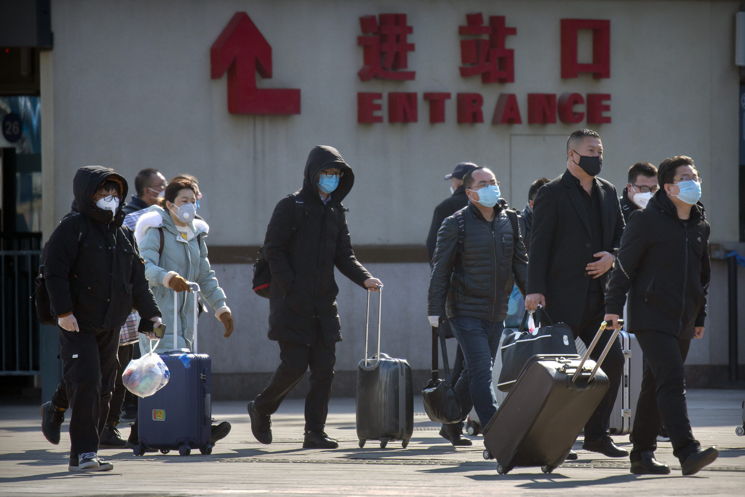coronavirus covid 19 Travelers wear face masks as they walk outside the Beijing Railway Station in Beijing, Saturday, Feb. 15, 2020. People returning to Beijing will now have to isolate themselves either at home or in a concentrated area for medical observation, said a notice from the Chinese capital's prevention and control work group published by state media late Friday. (AP Photo/Mark Schiefelbein)
