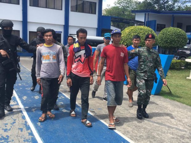 Policemen escort the three suspects in the killing of four policemen in Ayungon town, Negros Oriental last year