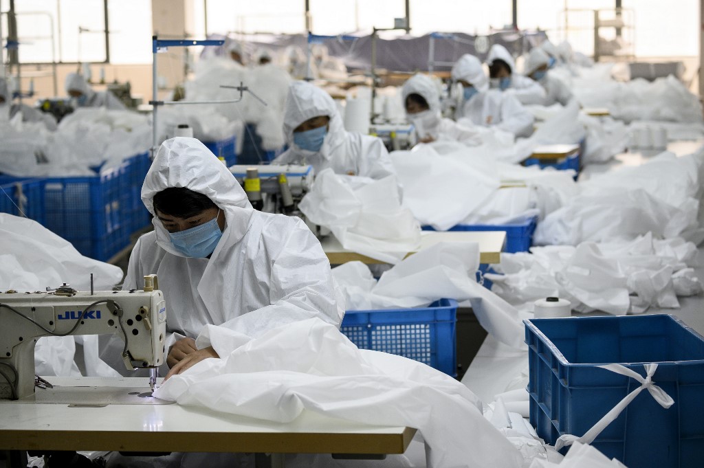 This photo taken on February 28, 2020, shows workers sewing at factory making hazardous material suits to be used in the COVID-19 coronavirus outbreak, at the Zhejiang Ugly Duck Industry garment factory in Wenzhou. - The coronavirus outbreak in China is preventing clothing manufacturer Ugly Duck Industry from resuming its normal production of winter coats, so it has pivoted to another in-demand product: hazmat suits. (Photo by NOEL CELIS / AFP) / TO GO WITH AFP STORY HEALTH-VIRUS-CHINA-HAZMAT-FACTORY,SCENE BY DAN MARTIN