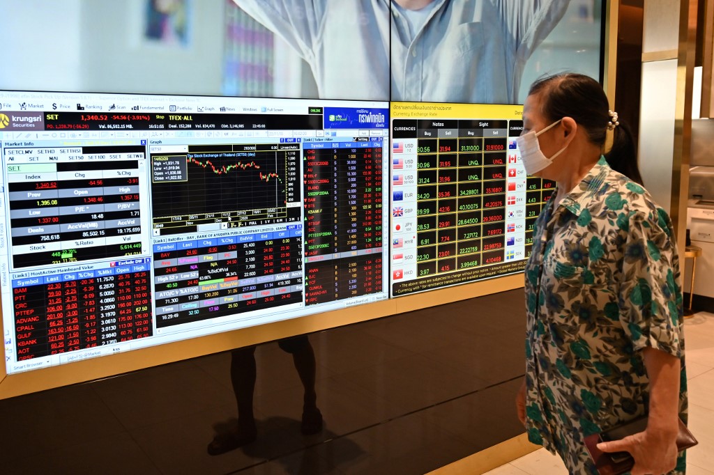 A woman wearing a protective face mask looks at an electronic quotation board displaying share prices of Bangkok Stock Exchange in Bangkok on February 29, 2020. - Global stocks slumped again on February 28 to mark the largest weekly drop since the 2008 global financial crisis over fears the coronavirus could wreak havoc on the world economy. (Photo by Romeo GACAD / AFP)