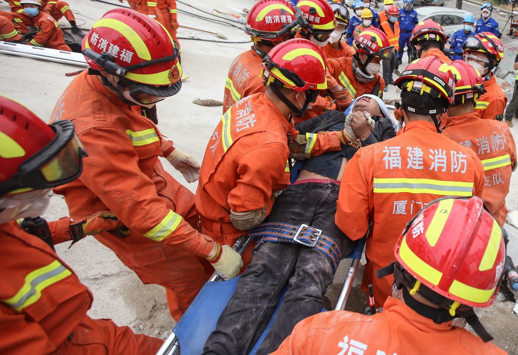 A man is rescued from the rubble of a collapsed hotel in Quanzhou, in China's eastern Fujian province on March 8, 2020. - At least four people were killed following the collapse of a hotel used as a coronavirus quarantine facility in eastern China, the Ministry of Emergency Management said on March 8. (Photo by STR / AFP) / China OUT