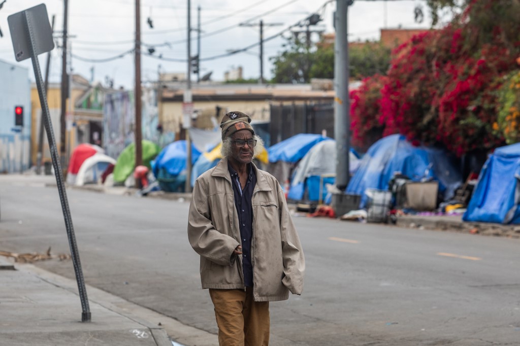 A homeless person walks on San Julian Street in the Skid Row area in downtown Los Angeles, California on March 19, 2020. - The US government is now preparing for 18 months of the coronavirus pandemic, including multiple waves of illnesses. The ominous announcement comes after cases in the US spiked 40% in just 24 hours. (Photo by Apu GOMES / AFP)