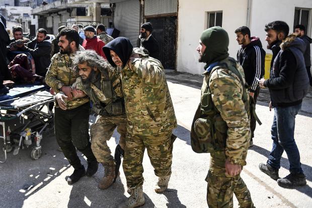Opposition fighters help wounded comrade in Syria