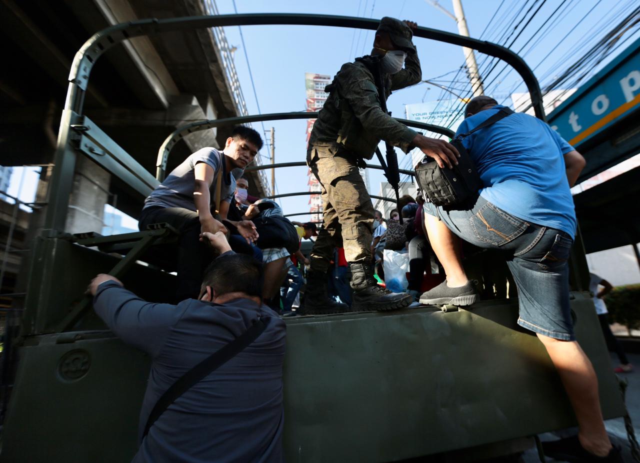 A military truck picks up passengers along EDSA on Wednesday, March 18, 2020, on the second day of the Luzon wide enhanced community quarantine to curb the spread of the coronavirus 5
