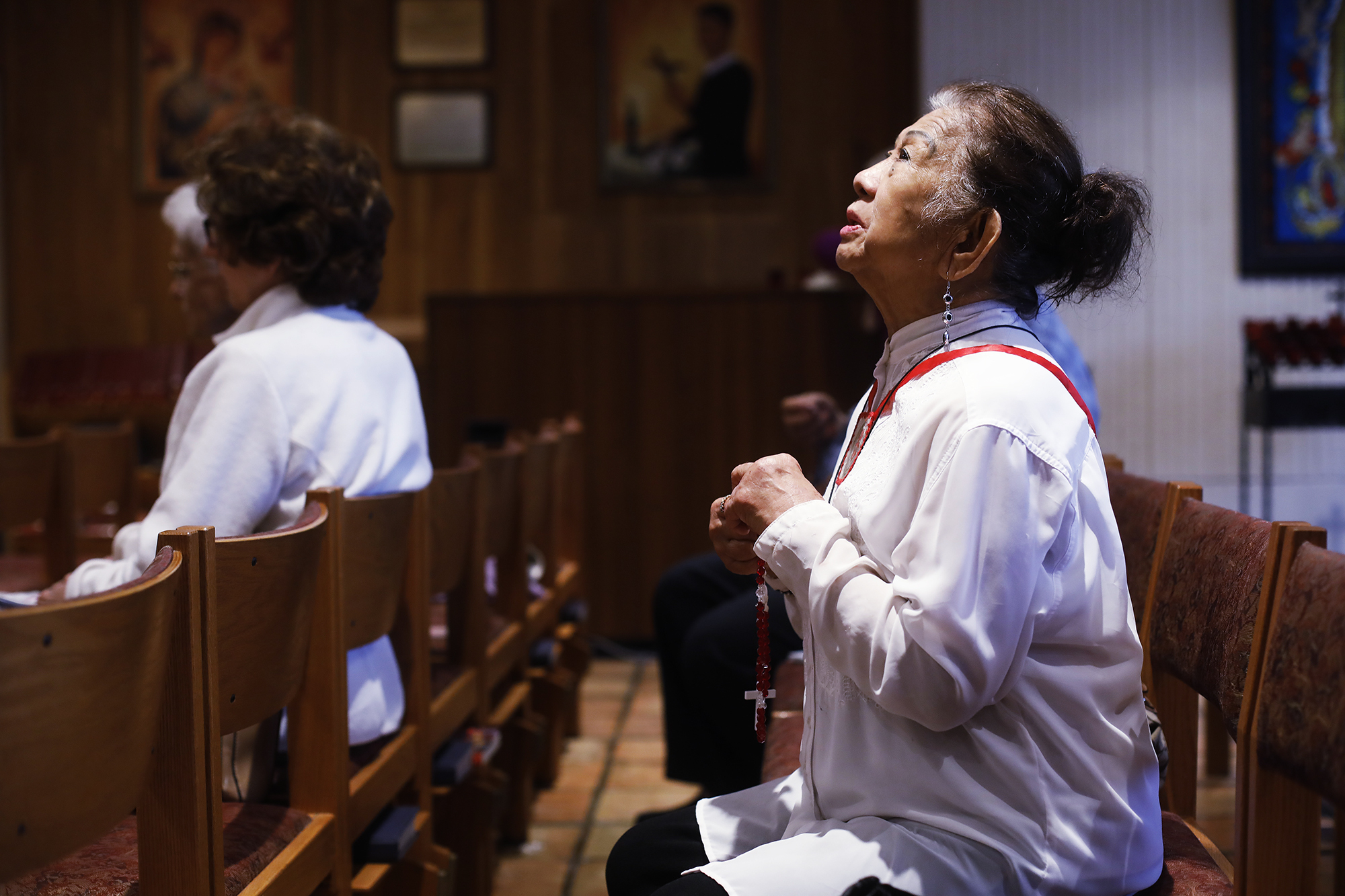 Esther Gianan, of Tampa, a retired registered nurse, prays for those who are affected by the coronavirus during Mass at St. Lawrence Catholic Church in Tampa, Fla., Friday, March 6, 2020. (Octavio Jones/Tampa Bay Times via AP)