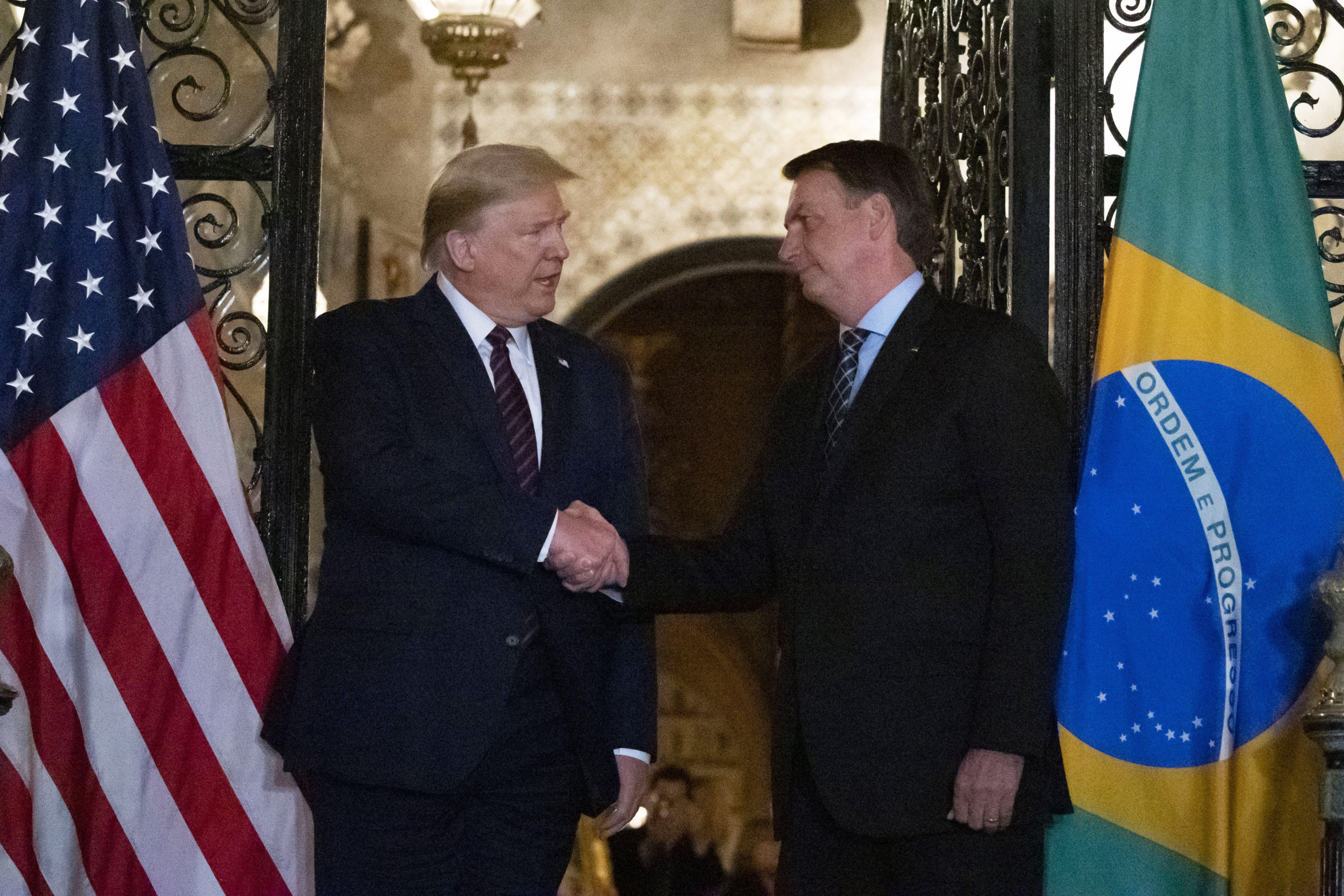 President Donald Trump shakes hands before a dinner with Brazilian President Jair Bolsonaro at Mar-a-Lago, Saturday, March 7, 2020, in Palm Beach, Fla. (AP Photo/Alex Brandon)