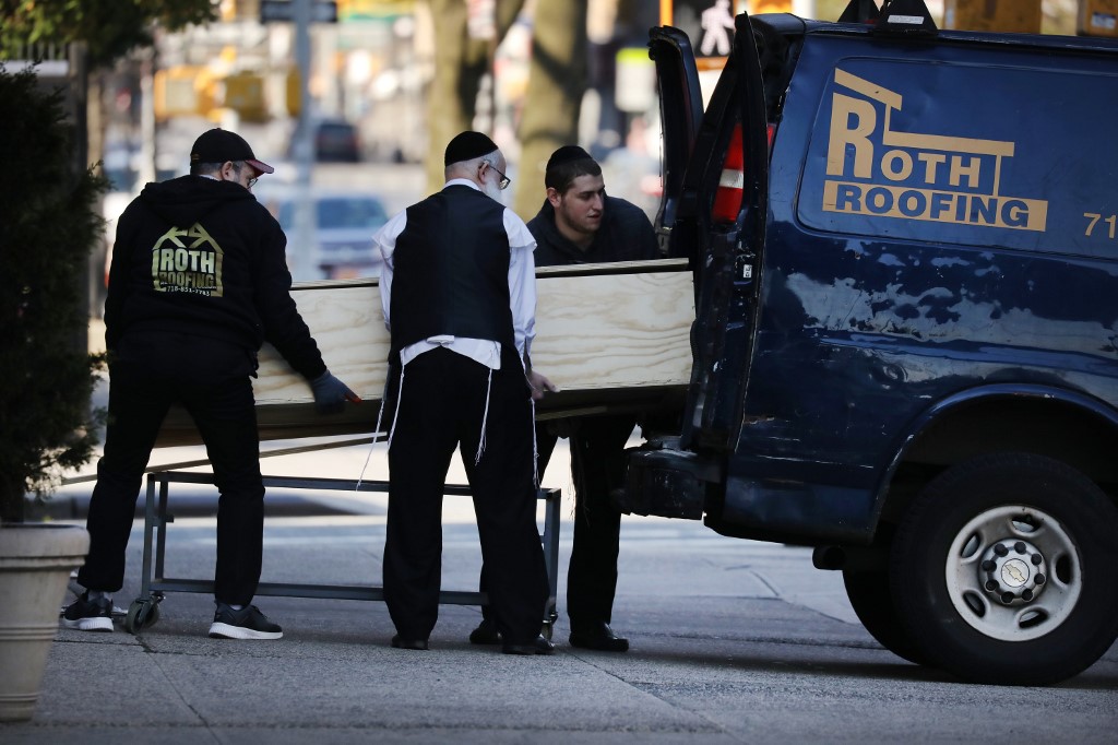 NEW YORK, NY - APRIL 19: A casket is placed into a van outside of a funeral home in the heavily Orthodox Borough Park neighborhood of Brooklyn which has scene a large number of deaths due to the coronavirus on April 19, 2020 in New York City. Hospitals in New York City, which have been especially hard hit by the coronavirus, are just beginning to see a slowdown of COVID-19 cases.   Spencer Platt/Getty Images/AFP