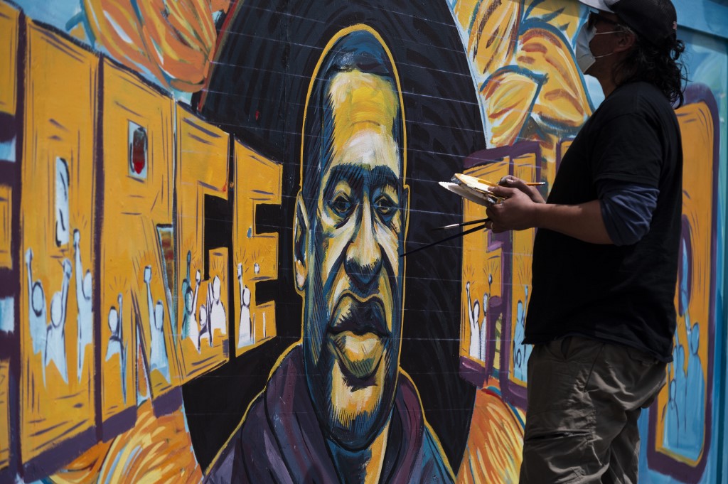 MINNEAPOLIS, MN - MAY 28: A group of artists paint a mural of George Floyd on the wall outside of Cup Foods, where Floyd was killed in police custody, on May 28, 2020 in Minneapolis, Minnesota. People have gathered at the site since Floyd was killed earlier this week.   Stephen Maturen/Getty Images/AFP