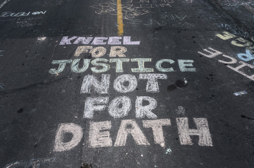 MINNEAPOLIS, MN - MAY 28: "Kneel for Justice not for Death" is written on the road outside the Cup Foods, where George Floyd was killed in police custody, on May 28, 2020 in Minneapolis, Minnesota. People have gathered at the site since Floyd was killed earlier this week.   Stephen Maturen/Getty Images/AFP