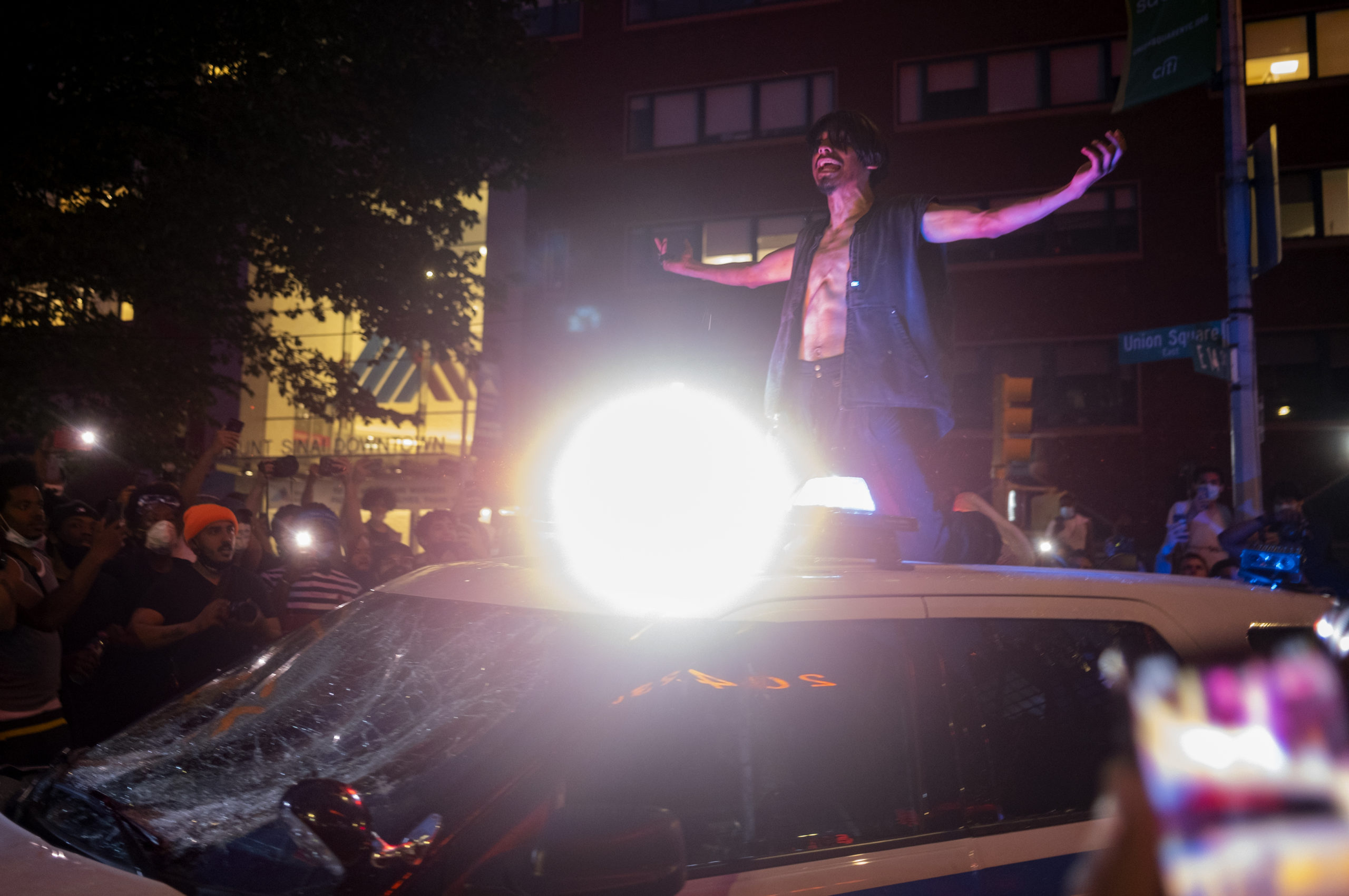 A protester gestures atop a damaged police vehicle near New York's Union Square, Saturday May 30, 2020, during a demonstration against the death of George Floyd, a black man who died in Minneapolis police custody on May 25. (AP Photo/Craig Ruttle)