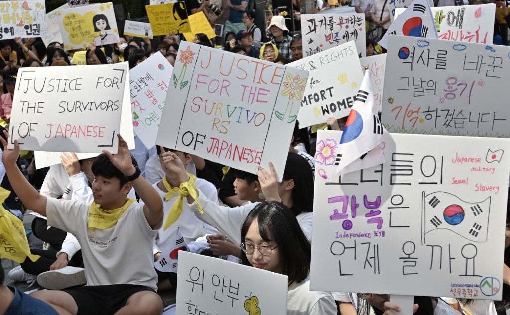 Supporters of former "comfort women", who were forced to serve as sex slaves for Japanese troops during World War II, hold placards during a demonstration demanding the Japanese government's formal apology near the Japanese embassy in Seoul on September 18, 2019. - South Korea on September 18 officially dropped Japan from its "white list" of trusted trade partners, the latest move in a bitter row stemming from Tokyo's use of forced labour during World War II. (Photo by Jung Yeon-je / AFP)