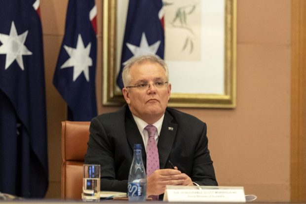 Australian Prime Minister Scott Morrison (C) attends a videoconference with G20 leaders to discuss the COVID-19 coronavirus, at the Parliament House in Canberra on March 26, 2020. - Leaders of the G20 major economies are holding an online summit on March 26, in a bid to fend off a coronavirus-triggered recession, after criticism the group has been slow to address the crisis. (Photo by Gary Ramage / POOL / AFP)