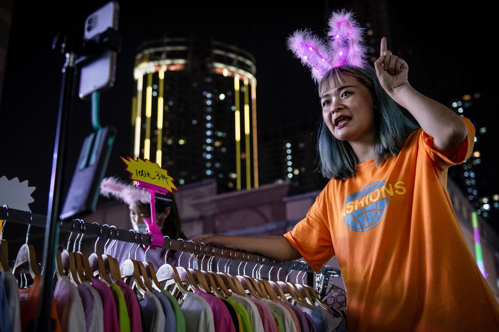 This photo taken on June 10, 2020 shows a vendor attracting customers at an outdoor market in Wuhan in China's central Hubei province. - Snacks, underwear, jewellery and even bunnies -- hard-hit Chinese are selling their wares on the street after the nation's premier appeared to give his support to hawkers despite long-standing curbs on the practice. (Photo by STR / AFP) / China OUT