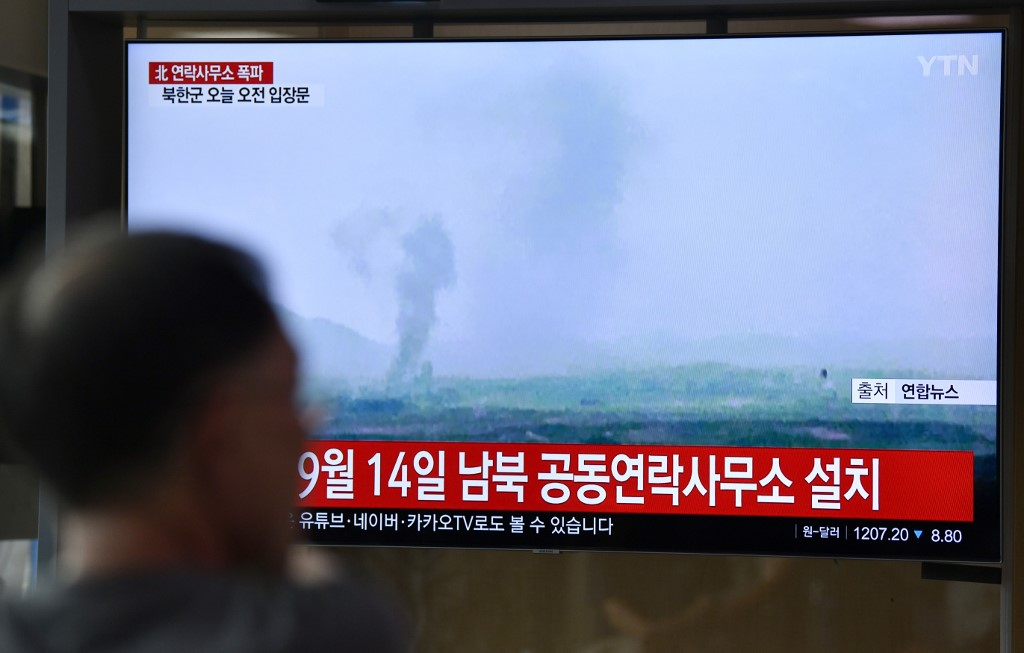 People watch a television news screen showing an explosion of an inter-Korean liaison office in North Korea's Kaesong Industrial Complex, at a railway station in Seoul on June 16, 2020. - North Korea blew up an inter-Korean liaison office on its side of the border on June 16, the South's Unification ministry said, after days of increasingly virulent rhetoric from Pyongyang. (Photo by Jung Yeon-je / AFP)