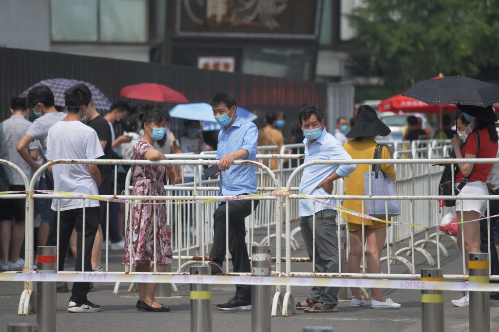 People wear masks as they wait in line to undergo COVID-19 coronavirus swab tests at a testing station in Beijing on June 28, 2020. Beijing has partially lifted a weeks-long lockdown imposed in the Chinese capital to head off a feared second wave of coronavirus infections after three million samples were taken in two weeks, officials said. Dozens of residential compounds across the city were shut down, with authorities rolling out a mass testing campaign to root out any remaining cases. - Beijing has partially lifted weeks-long lockdown imposed in the Chinese capital to head off a feared second wave of coronavirus infections after three million samples were taken in two weeks, officials said. Dozens of residential compounds across the city were shut down, with authorities rolling out a mass testing campaign to root out any remaining cases. (Photo by GREG BAKER / AFP)