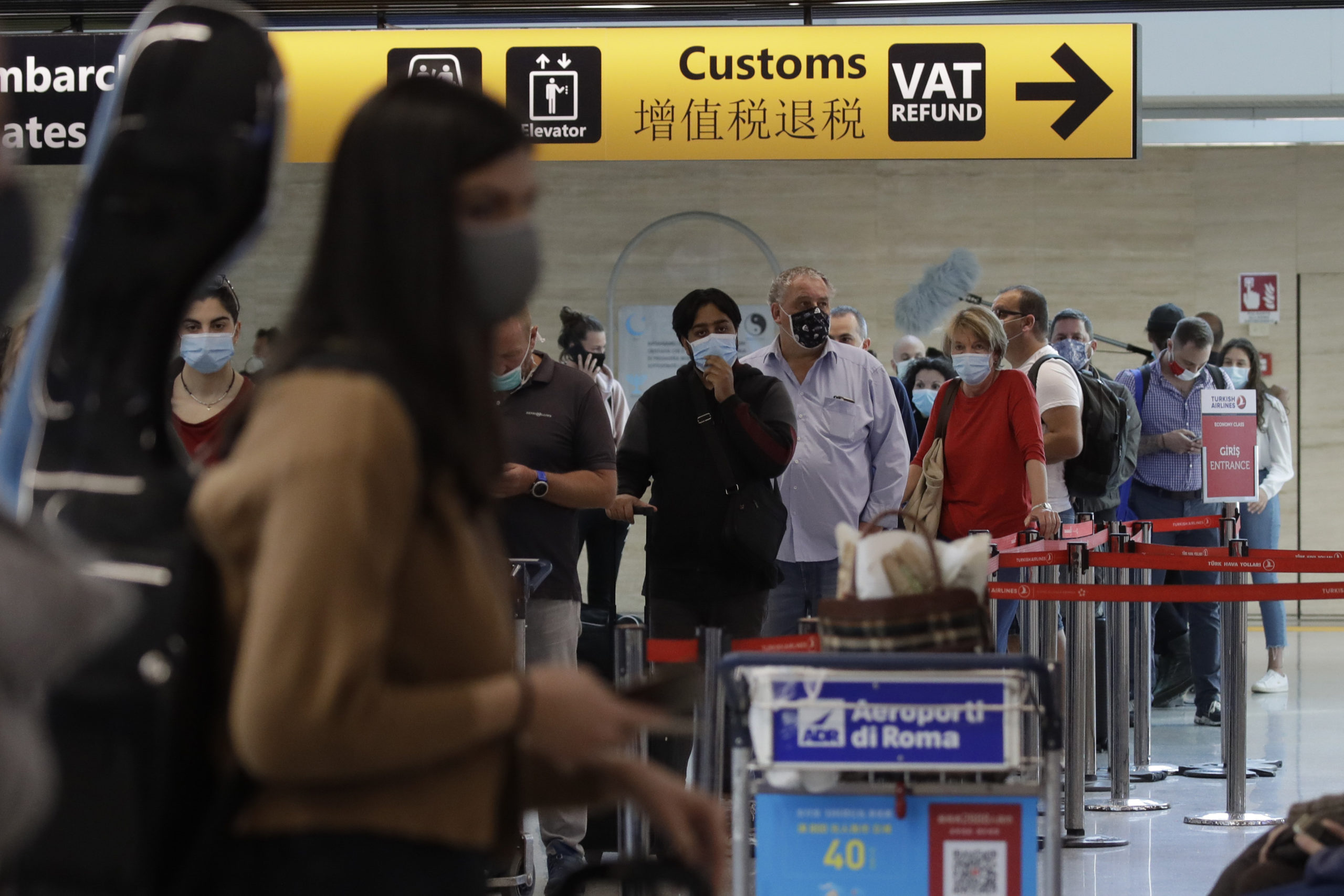 People wait in line at the check in for a flight to Dusseldorf, Germany, at Rome's Fiumicino airport, Wednesday, June 3, 2020. Italians and other EU citizens who got stuck in Italy during the coronavirus lockdown can now fly to European countries without restrictions and mandatory 14 days quarantine. (AP Photo/Alessandra Tarantino)