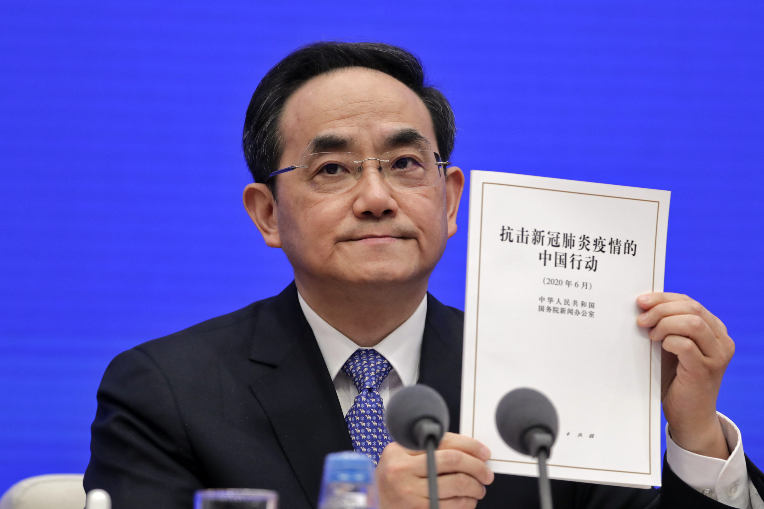 Xu Lin, Vice head of the Publicity Department of Communist Party shows a copy of the white paper on fighting COVID-19 China in action during a press conference at the State Council Information Office in Beijing, Sunday, June 7, 2020. Senior Chinese health officials defended their country's response to the new coronavirus pandemic, saying they provided information in a timely and transparent manner. (AP Photo/Andy Wong)