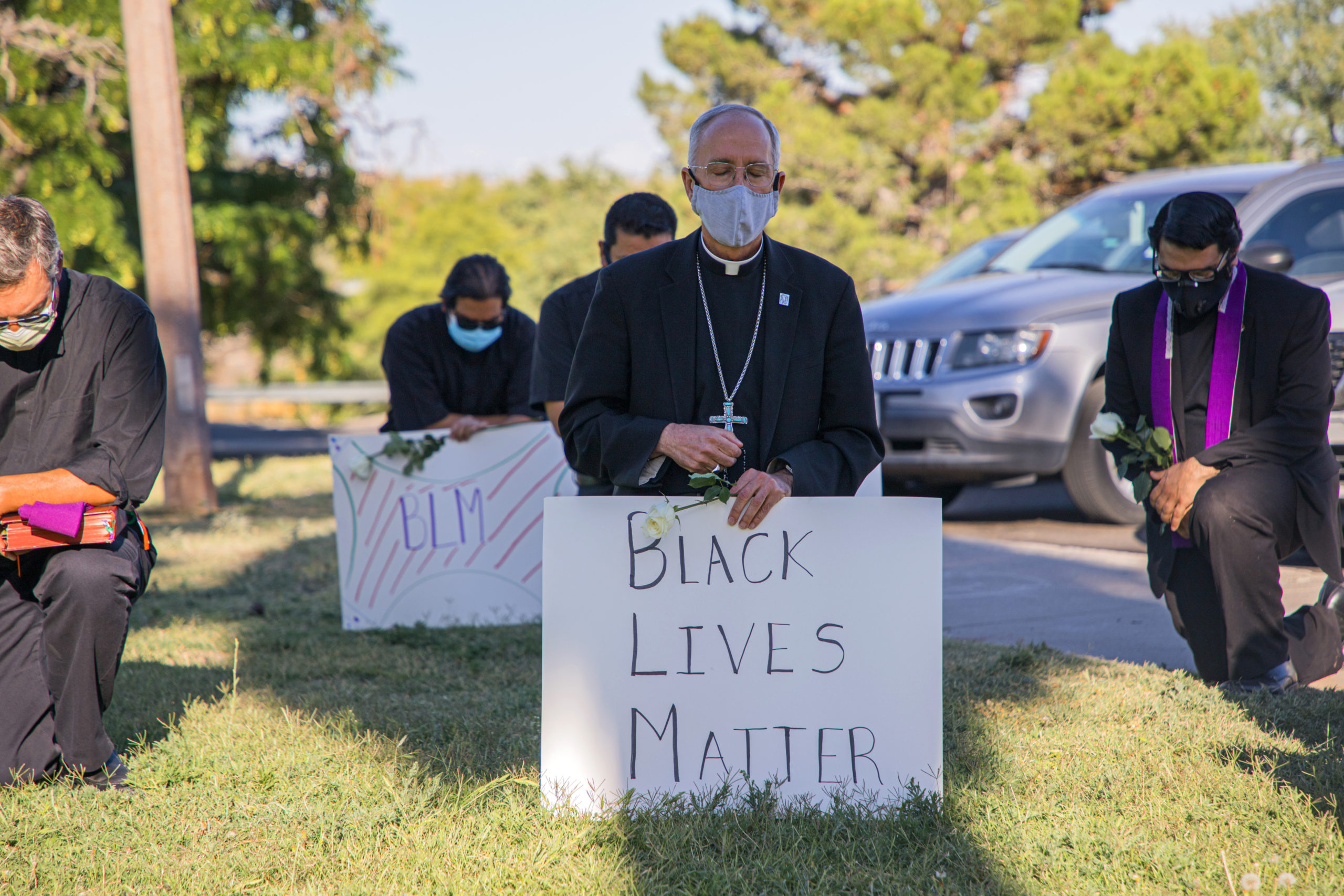 In this June 1, 2020, photo provided by the Catholic Diocese of El Paso, Bishop Mark Seitz, center, kneels with other demonstrators at Memorial Park holding a Black Lives Matter sign in El Paso, Texas. Pope Francis called Seitz unexpectedly after he was photographed at the protest. (Fernie Ceniceros/Catholic Diocese of El Paso via AP)