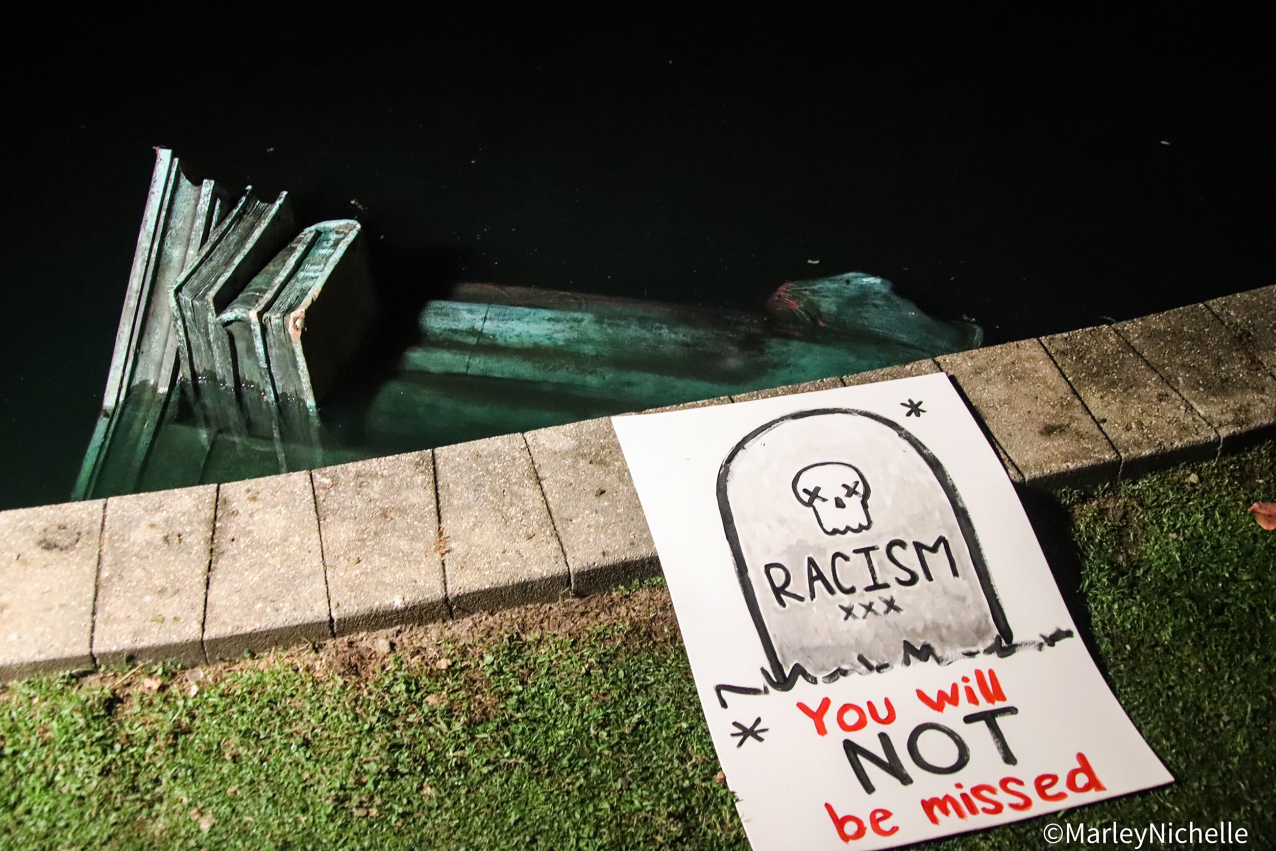 A statue of Christopher Columbus is in the water at Byrd Park in Richmond, Va. Tuesday, June 9, 2020, after it was torn down by protesters. The figure was toppled less than two hours after protesters gathered in the city’s Byrd Park were chanting for the statue to be taken down, news outlets reported. (@marleynichelle via AP)