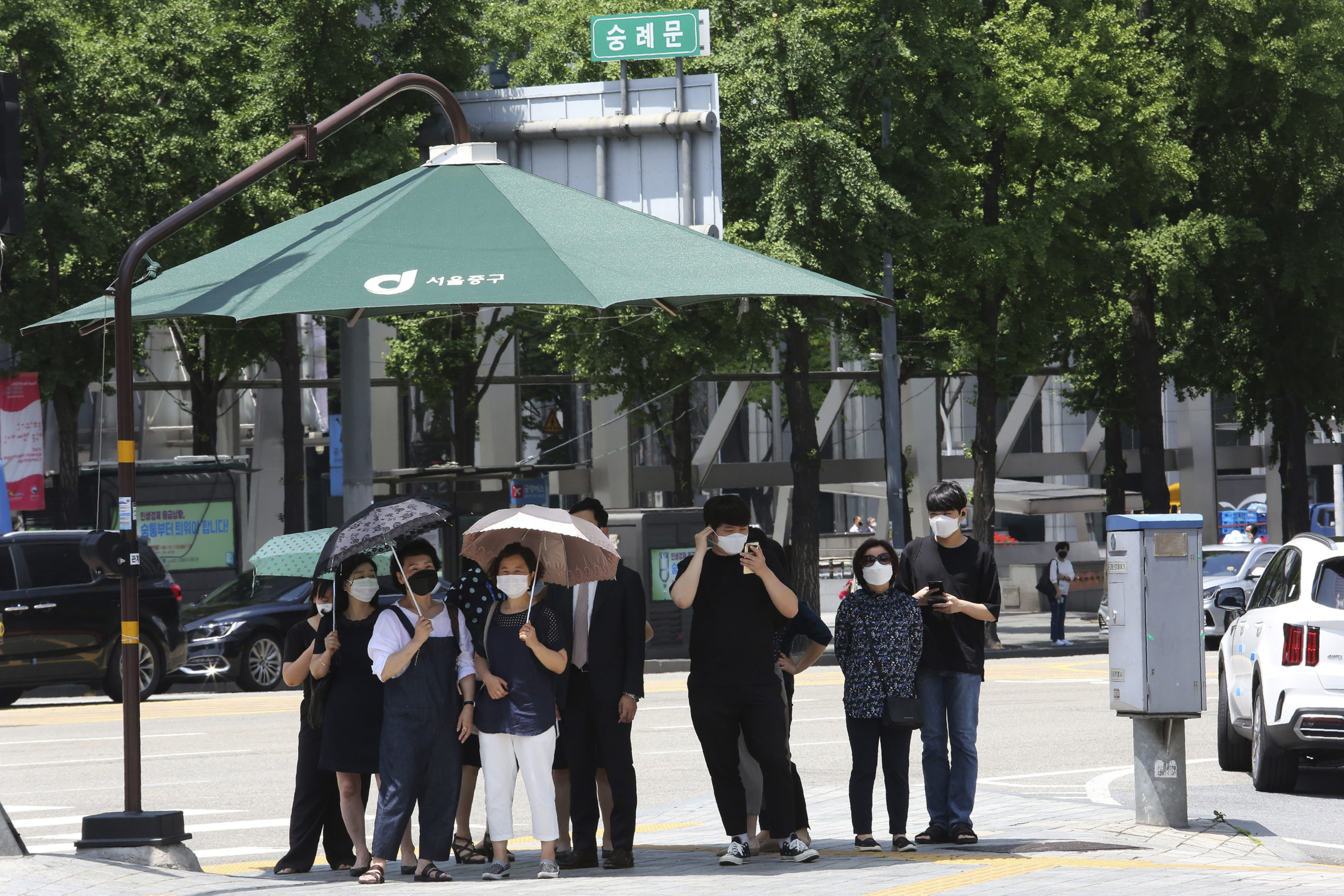 People, wearing face mask, wait to cross the road in Seoul, South Korea, Thursday, June 11, 2020. Just weeks ago, South Korea was celebrating its hard-won gains against the coronavirus, easing social distancing, reopening schools and promoting a tech-driven anti-virus campaign President Moon Jae-in has called “K-quarantine.” But a resurgence of infections in the Seoul region where half of South Korea’s 51 million people live is threatening the country’s success story and prompting health authorities to warn that action must be taken now to stop a second wave.(AP Photo/Ahn Young-joon)