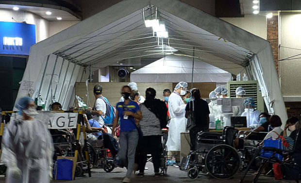 H RISK JOBS Health workers from the National Kidney and Transplant Institute in Quezon City tend to patients in the triage tent at the hospital. But they risk being exposed to the coronavirus by doing so. —GRIG C. MONTEGRANDE nkti