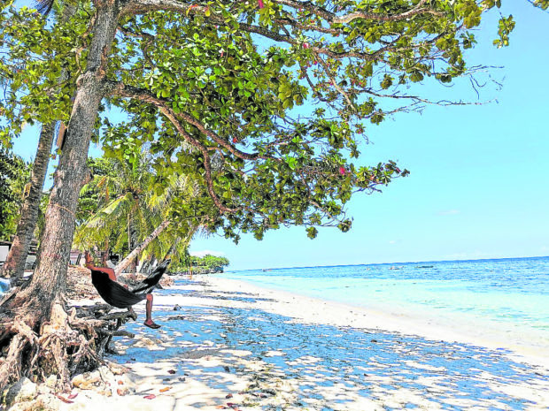 ** for t0612vis3 ** JUNE 11, 2020 In this June 11, 2020 photo, a man is seen relaxing in a hammock at an almost empty Alona Beach in Panglao Island, Bohol. Tourist visits had been suspended since the pandemic. INQUIRER FILE PHOTO / LEO UDTOHAN