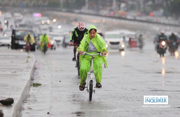 Bikers endure the rain with improvised raincoats and colorful raingears as they negotiate the stretch of Commonwealth Avenue