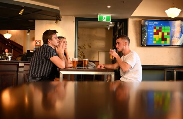 Patrons drink beer at a pub in the Rocks area of Sydney on June 1, 2020. - Social distancing regulations eased across Australia on June 1 with restaurants, pubs and cafes in New South Wales being allowed up to 50 patrons if social distancing is possible. (Photo by PETER PARKS / AFP)