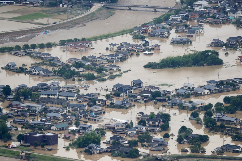 This picture shows inundated houses due to heavy rain in Hitoyoshi, Kumamoto prefecture on July 4, 2020. - Fourteen people were feared dead at a nursing home in western Japan on July 4 as record rainfall triggered massive floods and landslides, forcing authorities to issue evacuation advisories for more than 200,000 residents. (Photo by STR / JIJI PRESS / AFP) / Japan OUT