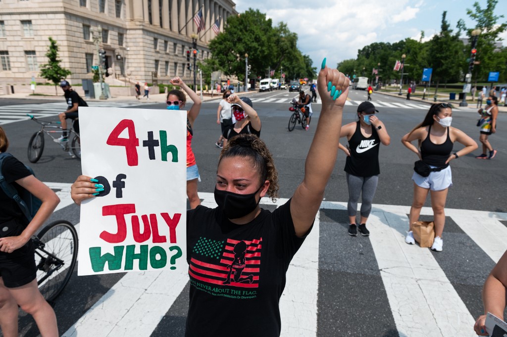 Anti racist demonstrators march near the Washington Memorial in Washington, DC on July 4, 2020, ahead of the Independence Day celebrations. - Wide spread national protests over police brutality and systemic racism have taken place following the police killing of George Floyd in Minneapolis in May. (Photo by ROBERTO SCHMIDT / AFP)