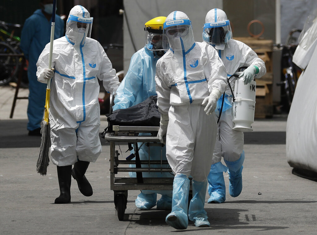 Health workers in protective suits transport a corpse at a hospital in Manila, Philippines, Thursday, Aug. 6, 2020. (AP Photo/Aaron Favila) COVID-19 coronavirus