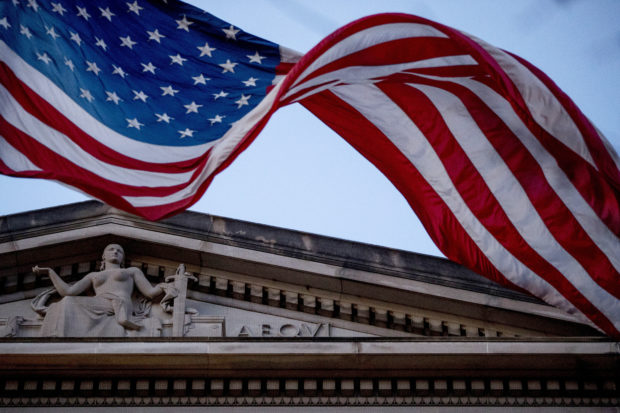 In this March 22, 2019 file photo, an American flag flies outside the Department of Justice in Washington. (AP File Photo/Andrew Harnik)