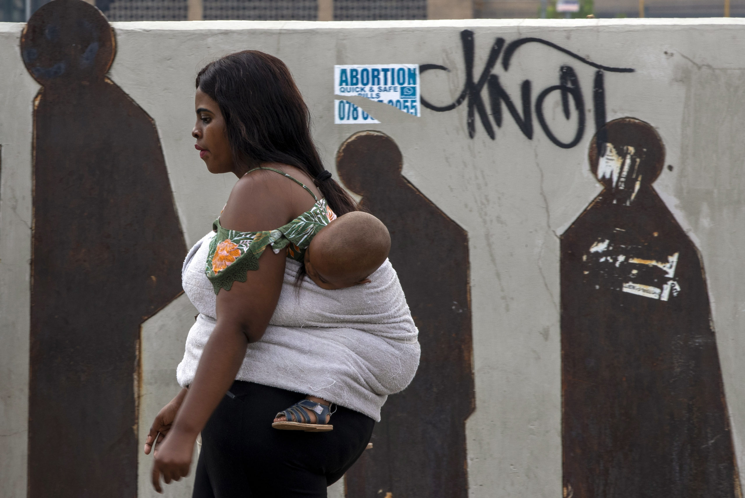 People walk along a downtown street in Johannesburg, South Africa, Monday, March 16, 2020. Millions of women and girls globally have lost access to contraceptives, abortion services and related care because of the coronavirus pandemic. Now the first widespread measure of the toll says India with its abrupt, months-long lockdown has been hit especially hard. (AP Photo/Themba Hadebe)