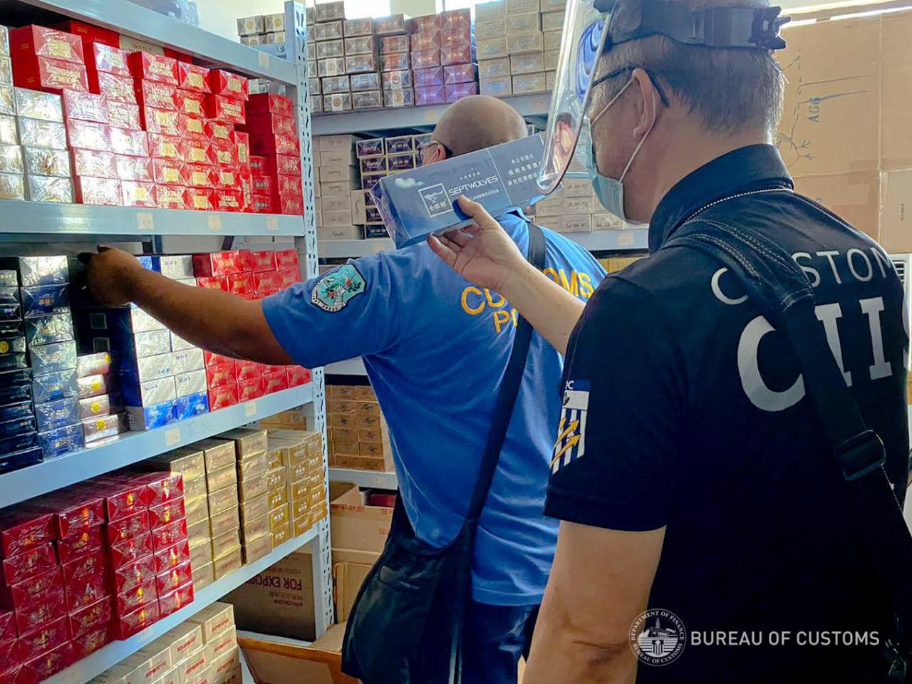 Personnel of the Bureau of Customs confiscate around P10 million worth of smuggled cigarettes, as well as unlicensed firearms and other items during a raid in a store and storage facility in Makati City on Tuesday, August 25, 2020. (Photo from BOC)