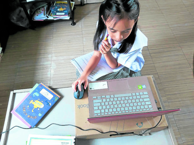 At home in Calamba, Laguna, a child wears a school uniform as she attends her second grade online class conducted a private school in Makati. Photo taken on Aug. 10, 2020. 