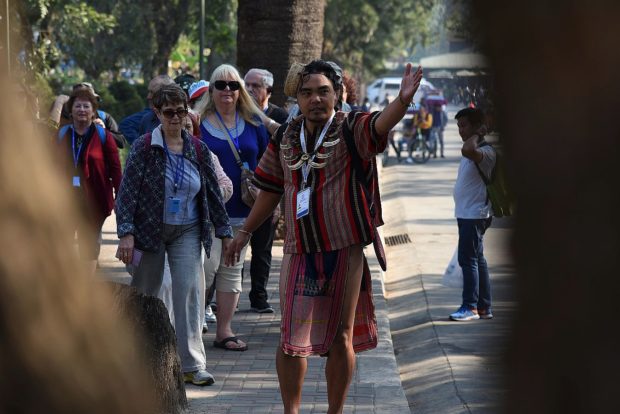 CULTURE GUIDE In this photo taken during the celebration of Ibaloy Day in 2019, a tour guide briefs a group of foreign tourists about the culture of the Ibaloy people, the original settlers of Baguio City. —EV ESPIRITU