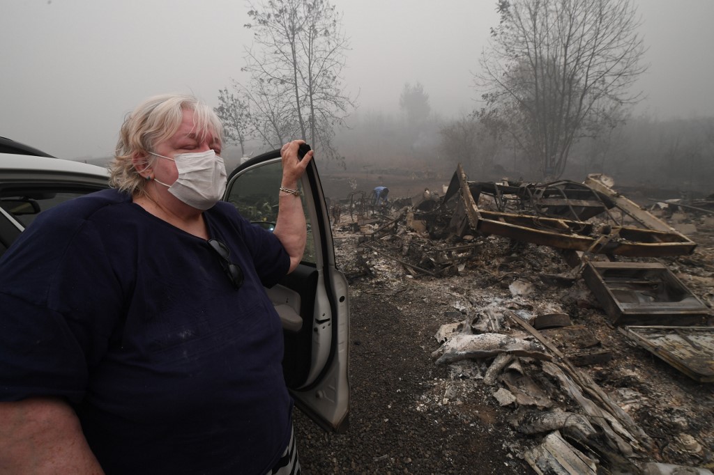 Resident Margi Wyatt arrives to find her mobile home destroyed by wildfire after she and her husband evacuated from the R.V. park earlier in the week, in Estacada, Oregon September 12, 2020. - US officials girded today for the possibility of mass fatalities from raging wildfires up and down the West Coast, as evacuees recounted the pain of leaving everything behind in the face of fast-moving flames. Dense smog from US wildfires that have burnt nearly five million acres and killed 27 people smothered the West Coast on September 12. (Photo by Robyn Beck / AFP)
