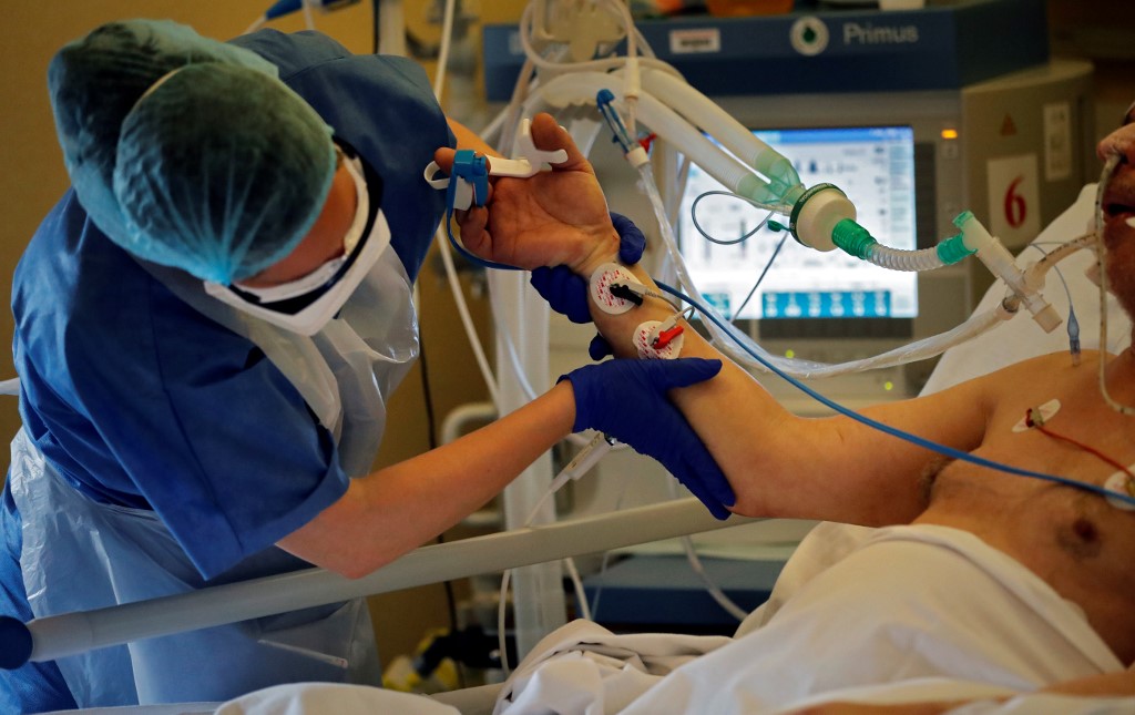 (FILES) In this file photo taken on April 07, 2020 A nurse tends to an intubated and sedated patient infected with COVID-19 at the intensive care unit of the Peupliers private hospital in Paris, on April 7, 2020, on the 22nd day of a strict lockdown in France aimed at curbing the spread of the COVID-19 pandemic, caused by the novel coronavirus. - More than 1,200 Covid-19 patients are now in intensive care in France, including 135 in the last 24 hours, according to figures from Public Health France published. There are now 1,232 people who have been placed in intensive care in total.  A figure well below the levels reached during the peak of the epidemic, with 7,000 patients in sheaves in early April, but which is progressing rapidly. (Photo by THOMAS COEX / AFP)