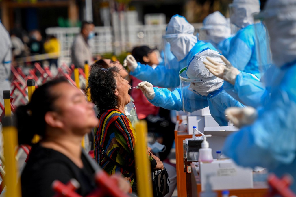 A health worker takes a swab from a resident to be tested for the COVID-19 coronavirus in Qingdao, in China's eastern Shandong province on October 12, 2020. (Photo by STR / AFP) / China OUT