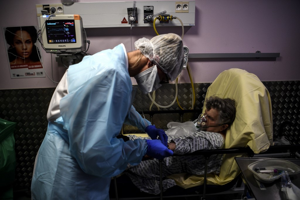 A nurse tends to an elderly woman suspected of being infected with Covid-19 at the emergency service of the Andre Gregoire hospital in Montreuil east of Paris on October 15, 2020. (Photo by Christophe ARCHAMBAULT / AFP)