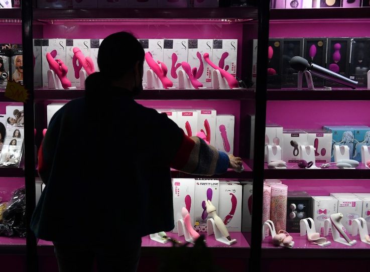 EDITORS NOTE: Graphic content / This photo taken on October 14, 2020 shows manager Li Hong in front of a display of sex toys at her sex store in Beijing. - Demand for sex toys is increasing in China, the world's biggest exporter of bedroom aids, partly thanks to the coronavirus and also a product of a wider cultural shift in attitudes towards sex by a younger and more open-minded demographic. (Photo by GREG BAKER / AFP) / TO GO WITH China-culture-economy-sex-health-virus,FOCUS by Laurie CHEN