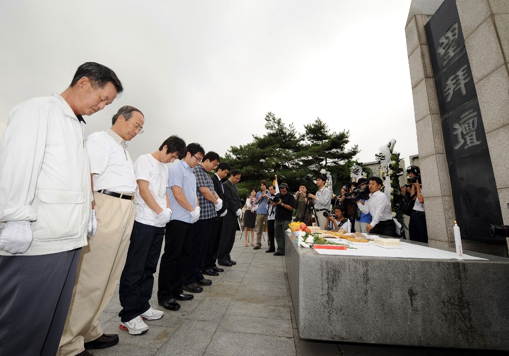 South Korean activists and defectors pray during a memorial service for North Koreans, who died in prison camps, and the victims of human rights abuses in the communist country, near the inter-Korean border in Paju on September 24, 2008. The service was held in front of a monument longing for peace and unification on the Korean peninsula.  AFP PHOTO/JUNG YEON-JE (Photo by JUNG YEON-JE / AFP)