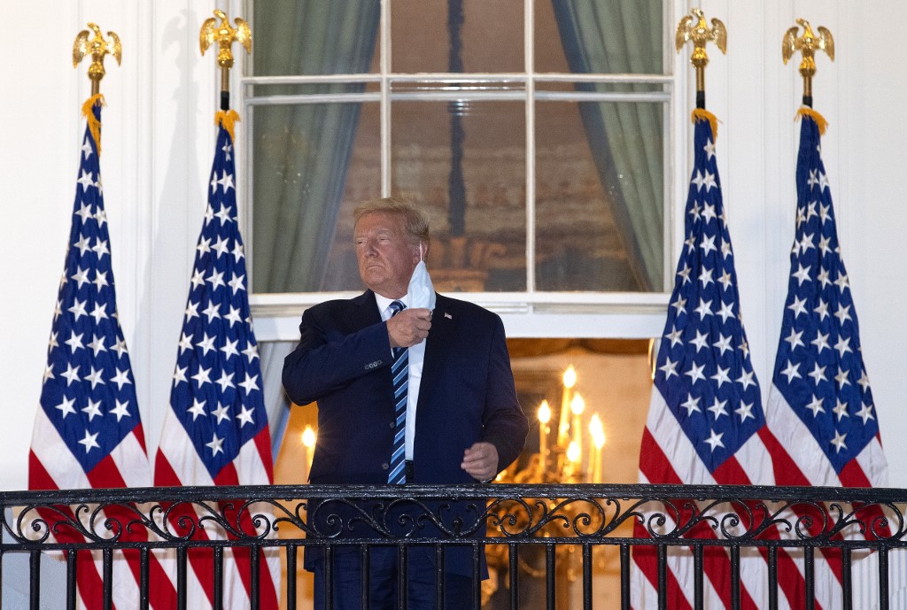 WASHINGTON, DC - OCTOBER 05: U.S. President Donald Trump removes his mask upon return to the White House from Walter Reed National Military Medical Center on October 05, 2020 in Washington, DC. Trump spent three days hospitalized for coronavirus.   Win McNamee/Getty Images/AFP