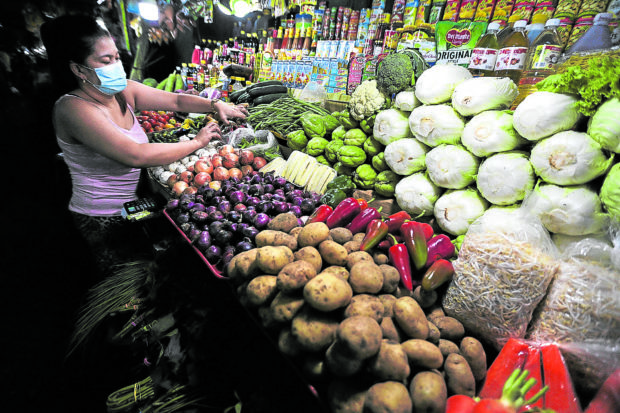 A market vendor at her stall in Commonwealth Market in Quezon City. STORY: Lower duties on food imports OK, but long-term policies needed – senators