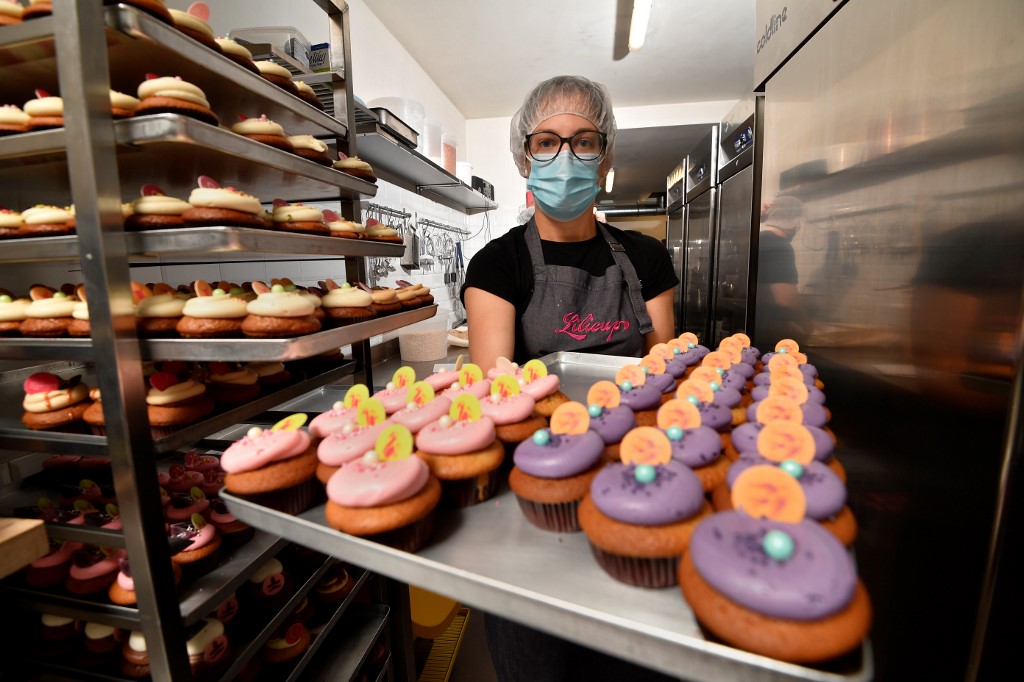 Nolwenn Le Bonzec, a former nurse who quit her job at the Saint-Luc hospital during the first wave of the novel coronavirus Covid-19, holds a tray with cupcakes at Lilicupcake on November 6, 2020, her new job where she creates cupcakes. (Photo by JOHN THYS / AFP)