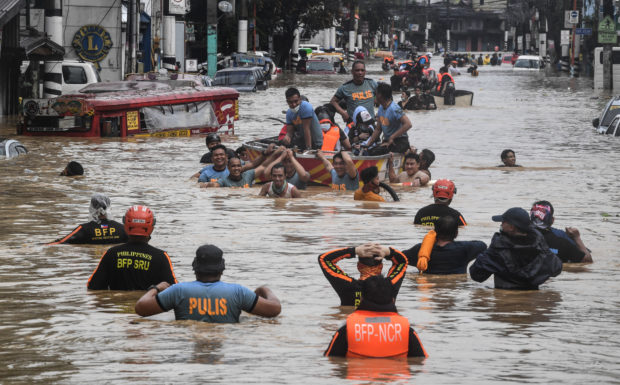 Rescuers pull a rubber boat carrying residents through a flooded street after Typhoon Vamco hit in Marikina City, suburban Manila on November 12, 2020. (Photo by Ted ALJIBE / AFP)