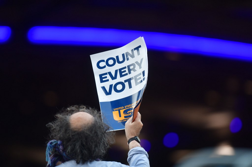 PHILADELPHIA, PA - NOVEMBER 9: A man holds a placard that reads "Count Every Note" while demonstrating across the street from supporters of President Donald Trump outside of where votes are still being counted, six days after the general election on November 9, 2020 in Philadelphia, Pennsylvania. The state was called for President-elect Joe Biden on Saturday, propelling him past the requisite 270 electoral votes to win the presidency. With 98% of the ballots reported, President-elect Biden leads President Trump by 45,595 votes.   Mark Makela/Getty Images/AFP
